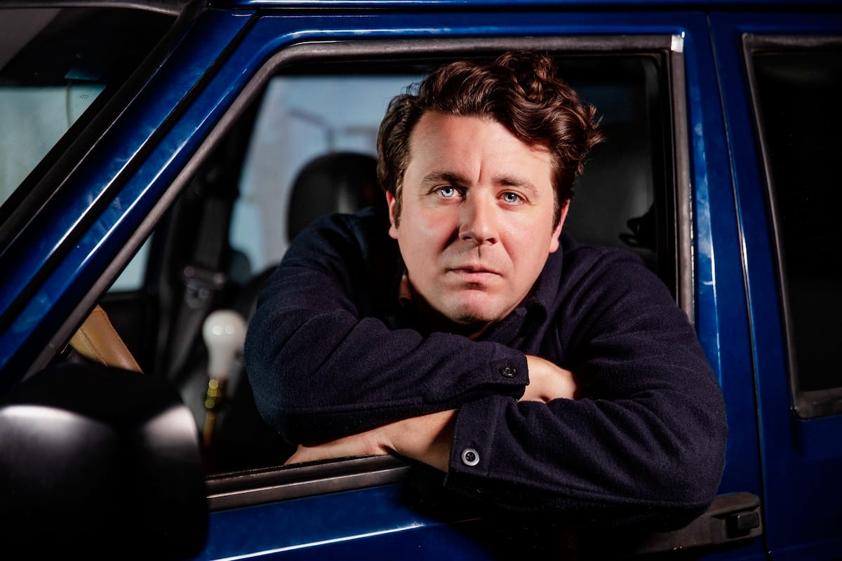 Joe Pug leans out the window of a car