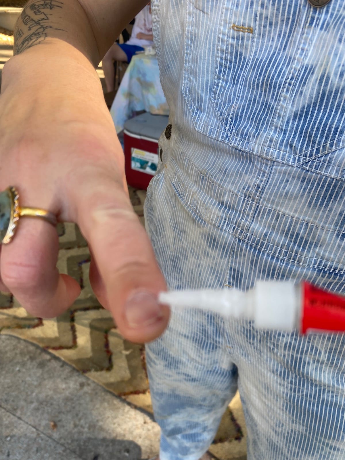 Closeup of superglue being applied to a banjo players fingernail