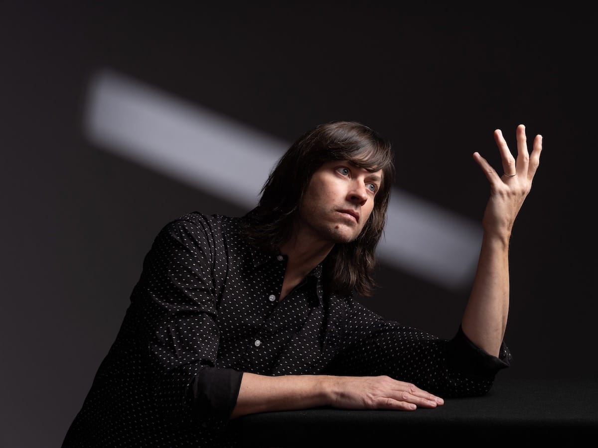 Rhett Miller looks at his hand in a moody portrait