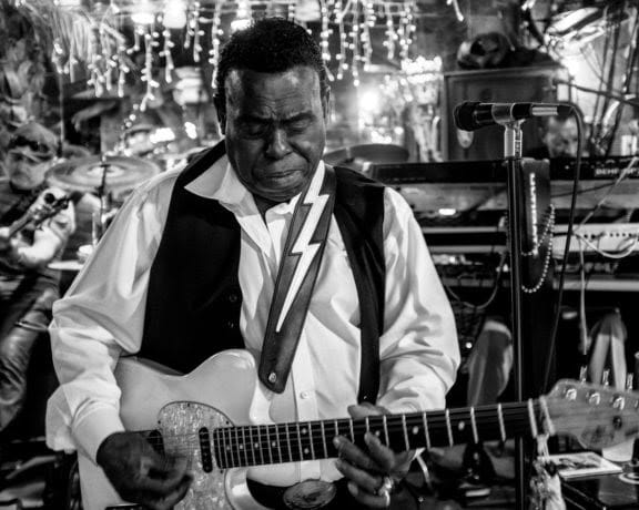 Black and white portrait of a man with electric guitar