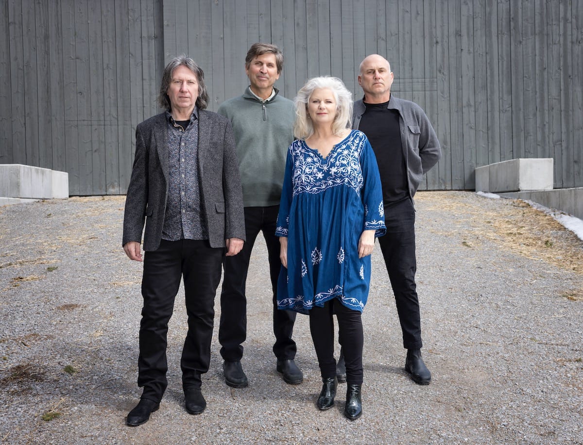 The four members of Cowboy Junkies pose in gravel lot