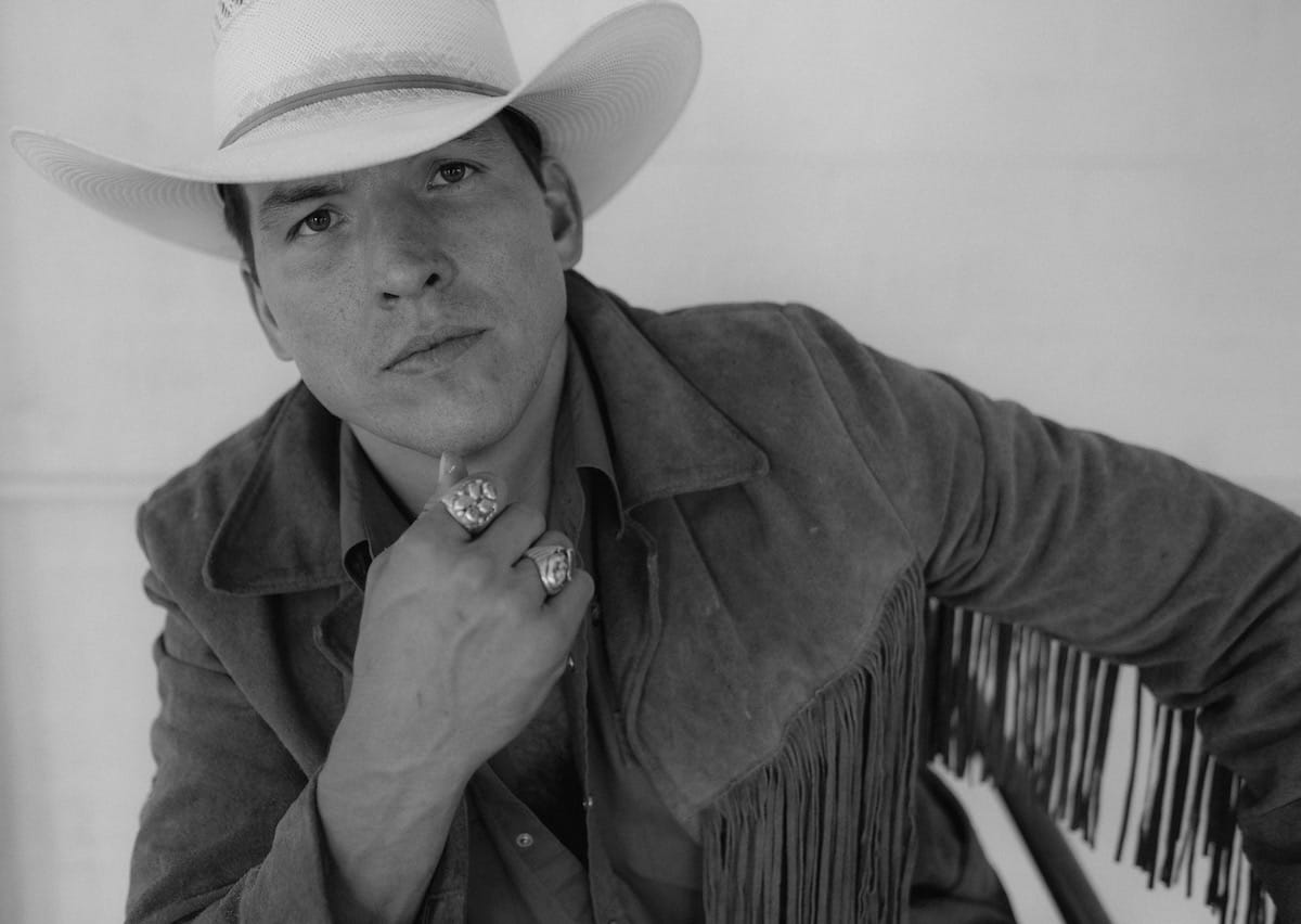 Black and white portrait of Dallas Burrow in light hat and fringed jacket
